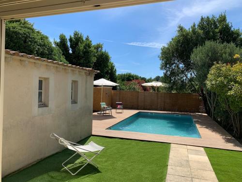 une cour avec une piscine et une pelouse avec des chaises dans l'établissement 140 m2 villa with pool in Pernes-Les-Fontaines, à Pernes-les-Fontaines