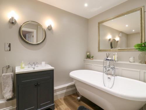 a bathroom with a tub and a sink and a mirror at BB House in Bedford