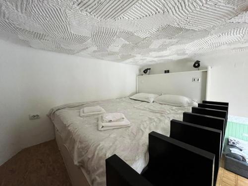 a bedroom with a bed with a white ceiling at Architectural Gem with Modern Flair - Double Studio Old Town in Bucharest