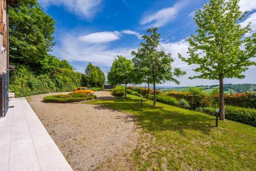 a path in a park with trees and a yellow car at Residenza Storica sulle Colline di Maranello in Fogliano