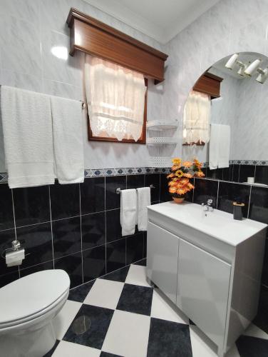 a bathroom with a white toilet and a sink at Vila Teixeira in Amarante