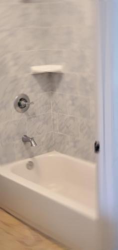 a bathroom with a white tub and a sink at El Rio Motel in Glendale