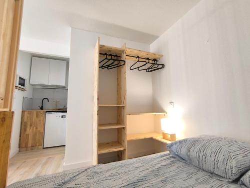 une petite chambre avec un lit et une cuisine dans l'établissement Fun 5, à La Rochelle
