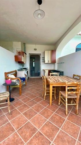a kitchen with a table and chairs in a room at Gentileza Procida in Procida