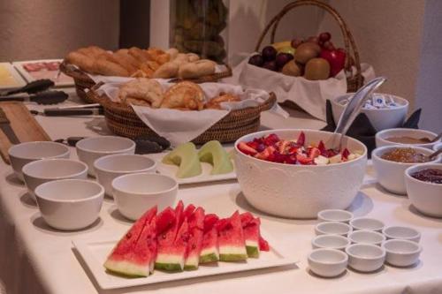 a table with fruits and other foods on it at Libertad Hotel Buenos Aires in Buenos Aires