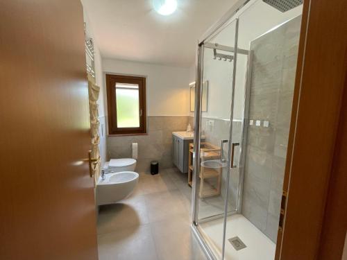 a bathroom with a glass shower and a sink at Casa nel vigneto con vista mare in Magomadas