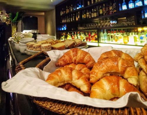 a basket of croissants and other pastries on a counter at Libertad Hotel Buenos Aires in Buenos Aires