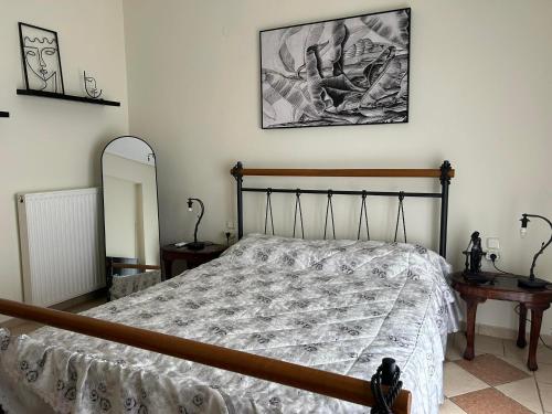 a bedroom with a bed and two tables and a mirror at La Casa Tzortzina in Kókkinon Nerón