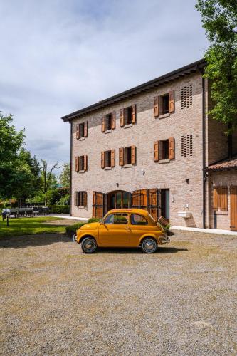 a yellow car parked in front of a building at Residenza Storica sulle Colline di Maranello in Fogliano