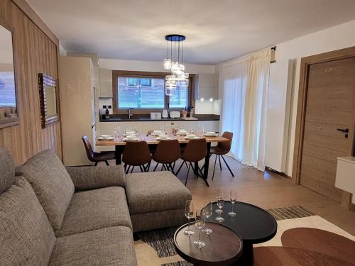 un salon avec un canapé et une table avec des chaises dans l'établissement Appartement central tout confort avec grande terrasse, WIFI, PARKING, 8 personnes - FR-1-598-99, aux Gets