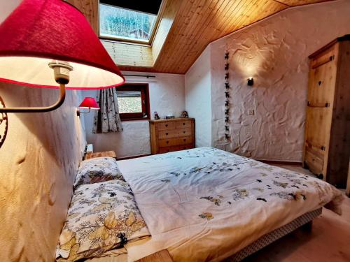 - une chambre avec un lit et une lampe rouge dans l'établissement Appartement lumineux avec terrasse, parking et WiFi aux Gets - FR-1-598-51, aux Gets