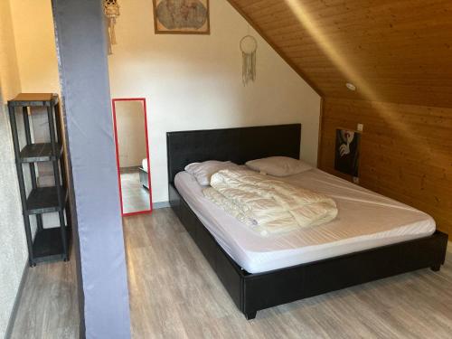 une chambre avec un lit dans un grenier dans l'établissement Appartement au calme, à La Bresse
