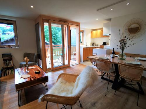 un salon avec une table et des chaises et une cuisine dans l'établissement Appartement lumineux avec terrasse, proche pistes et commodités, Les Gets - FR-1-598-93, aux Gets