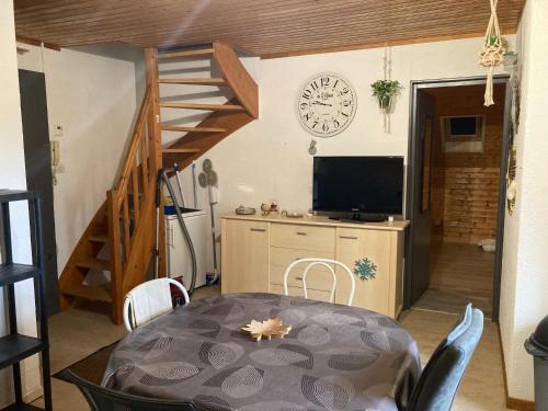 une salle à manger avec une table et une horloge au mur dans l'établissement Appartement au calme, à La Bresse