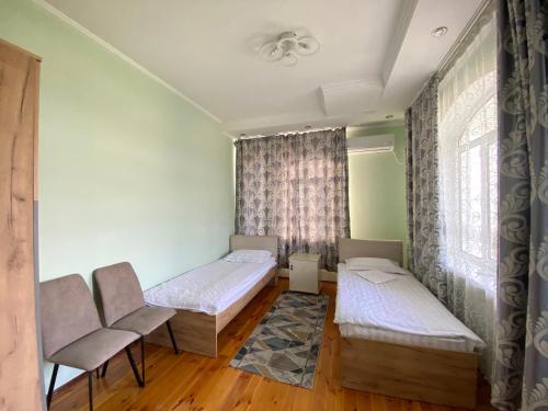 a room with two beds and a window at Green Yard in Osh