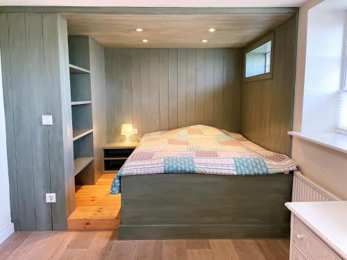 a bedroom with a bed in the corner of a room at Ferienhaus Dat groote Diekhuus Rodenäs in Rodenäs