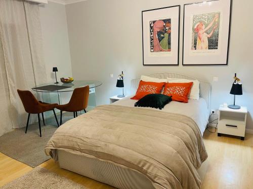 a bedroom with a bed with orange pillows and a table at The Yellow Retreat in A dos Cunhados