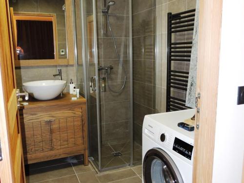 La salle de bains est pourvue d'une douche, d'un lavabo et d'un lave-linge. dans l'établissement Charmant triplex 3* avec parking, WiFi, proche centre village - FR-1-598-32, aux Gets