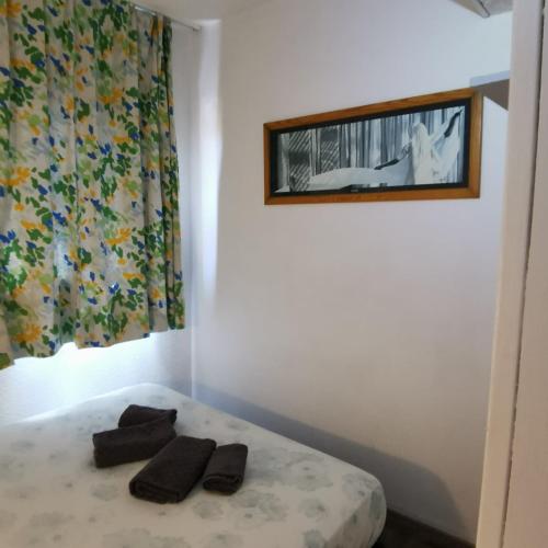 une chambre avec un lit avec deux pantoufles noires dessus dans l'établissement Sylvabelle Gigaro Sea Lounge 2, à La Croix-Valmer