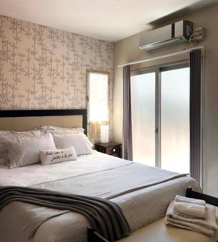 a bedroom with a large white bed and a window at CardON Apart in San Fernando del Valle de Catamarca