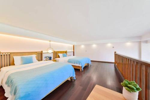 a hotel room with two beds and a balcony at 大理顾里海景别墅Dali Guli Sea View Villa Hotel in Dali