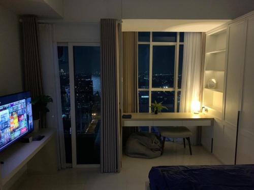 a bedroom with a desk and a window with a view at Cozy Studio Roseville BSD City by alonelyroom in Dadap