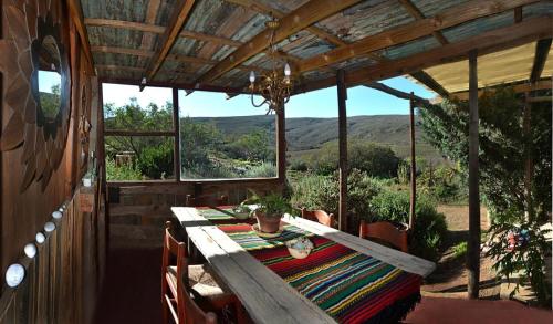 a wooden table on the porch of a house at Wooden Cabin Barrydale in Barrydale