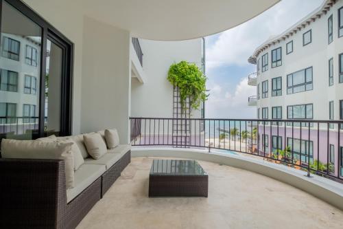 a living room with a couch and a balcony at Diamante Beachfront Suites in San Pedro
