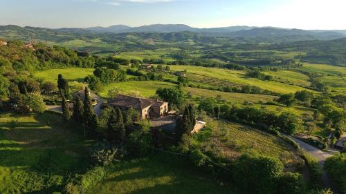 een luchtfoto van een huis in een groen veld bij Monti 1824 - Apartments & Cottages in Casole dʼElsa