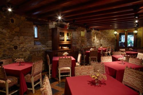 a restaurant with red tables and chairs in a room at Hotel Rural Casa Xusto in La Caridad