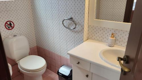 a bathroom with a white toilet and a sink at Villa Golden Sun with swimming pool and jacuzzi in Anavissos