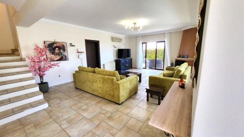 a living room with two couches and a table at Villa Golden Sun with swimming pool and jacuzzi in Anavissos