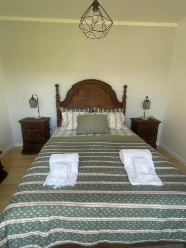 a bedroom with a large bed with two pillows at The Yellow Retreat in A dos Cunhados