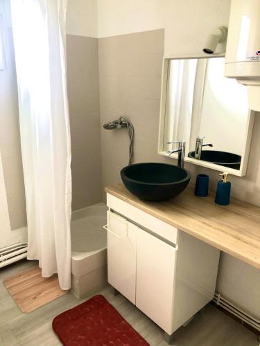 La salle de bains est pourvue d'un lavabo noir sur un comptoir. dans l'établissement Studio L envie d ailleurs, à Marseillan