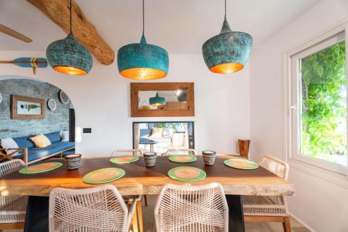 a dining room with a wooden table and chairs at Villa Zina Sunset View St Lazaros 7 plus 1 Bedroom in Psarou