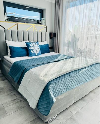 a bedroom with a large bed with blue pillows at Apartamenty BLUE BALTIC SPA Jacuzzi & Sauna MORZE in Chłopy