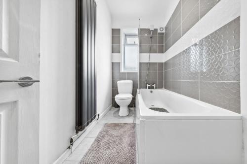 a bathroom with a white tub and a toilet at 2-Bed House, Bromley, Free Parking, 30 min to Central London - Sleeps 6 in London