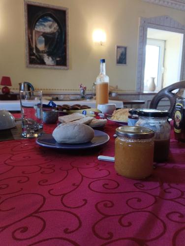 a table with a red table cloth with food on it at Casa de Artista in Figueiró dos Vinhos