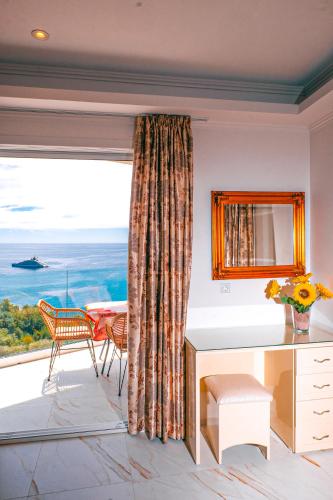 a room with a large window with a desk and a table at Valtos View in Parga