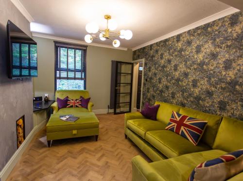 a living room with a green couch and a chair at NEW Refurbished 2025 Cottage Sleeps 6 Ashbourne Peak District Derbyshire in Ashbourne