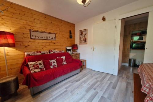- un salon avec un canapé rouge et des murs en bois dans l'établissement Apartment with garden in Demi-Quartier, à Demi-Quartier