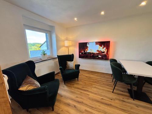 a room with chairs and a table and a fireplace at harmony holiday, Pension in Kerschenbach