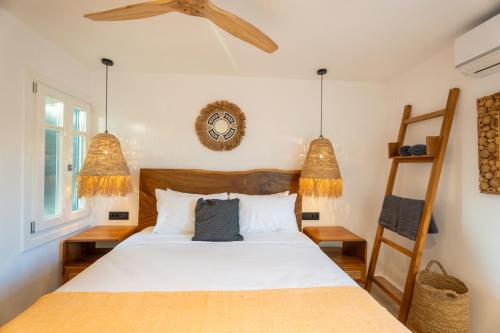 a bedroom with a bed and a ladder and a clock at Villa Zina Sunset View St Lazaros 7 plus 1 Bedroom in Psarou