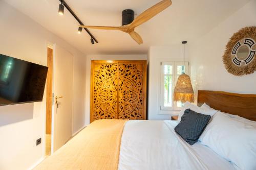 a bedroom with a white bed and a wooden door at Villa Zina Sunset View St Lazaros 7 plus 1 Bedroom in Psarou