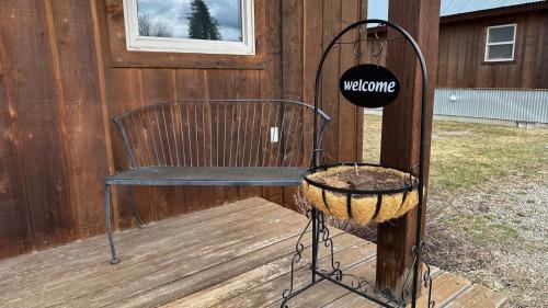 a wooden deck with a bench and a welcome sign at Methow River Lodge and Cabins in Winthrop