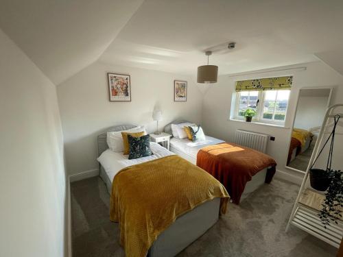 sypialnia z dwoma łóżkami i oknem w obiekcie Spacious Family Friendly Cottage w mieście Tarporley