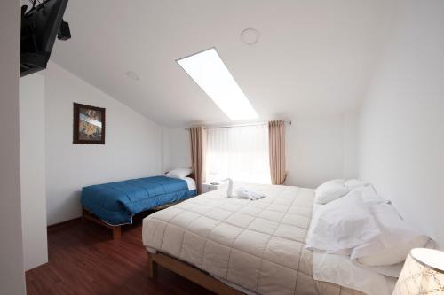 a bedroom with a white bed and a blue couch at Carmen's House in Cusco
