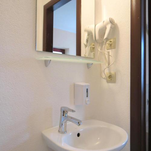 a bathroom sink with a mirror and a phone at Villa Kmeller in Lviv