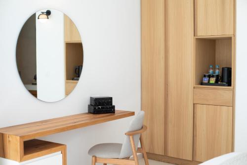a bedroom with a mirror and a chair and a desk at Paradise View Hotel in Paradise Beach