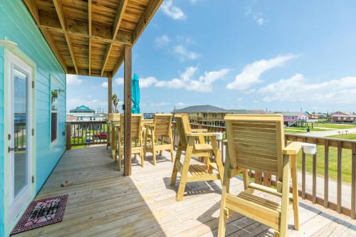 a deck with wooden chairs and a view of the ocean at Paradise Found - Great Location - Family Friendly in Surfside Beach